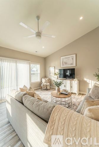 Columbiana house for rent - A living room with a grey sofa and a television on a white cabinet.