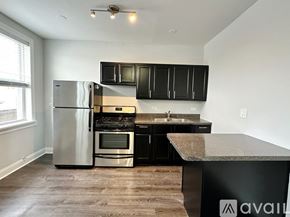 Chicago apartment for rent - A kitchen with black cabinets and a stainless steel refrigerator.