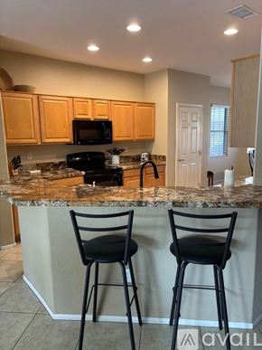Surprise apartment for rent - A kitchen with granite countertops and wooden cabinets.