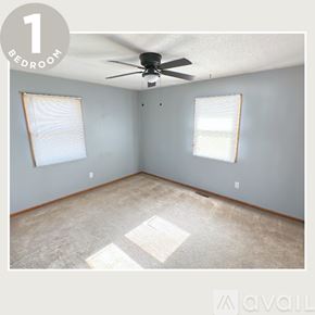 Alton apartment for rent - A bedroom with a ceiling fan and two windows.
