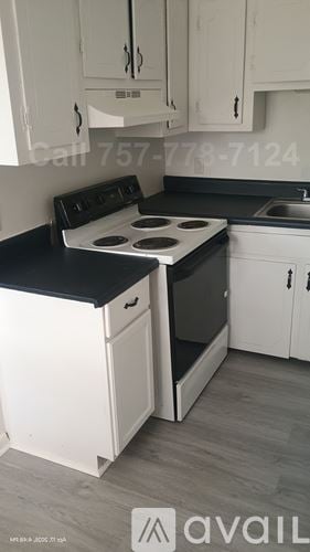 Norfolk apartment for rent - A kitchen with wooden cabinets and a white fridge.