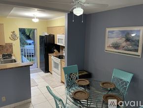 Fort Lauderdale apartment for rent - A kitchen with a table set for two with a palm tree picture on the wall.