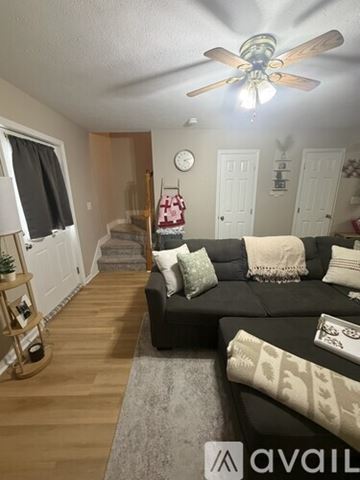 Paducah apartment for rent - A living room with a black leather couch and a flat screen TV on a wooden cabinet.