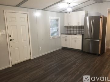 Adams Center house for rent - A kitchen with white cabinets and a stainless steel refrigerator.