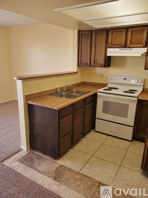 Bullhead City apartment for rent - A kitchen with a white stove and wooden cabinets.