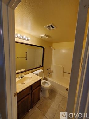 Bullhead City apartment for rent - A bathroom with a toilet, sink, and mirror.