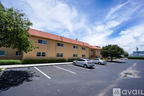 Deerfield Beach apartment for rent - A parking lot in front of a building with a car parked.