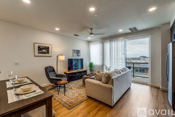 New Braunfels apartment for rent - A living room with a couch, chair, and a dining table with plates on it.