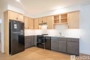 Altoona apartment for rent - A kitchen with wooden cabinets and a black fridge.