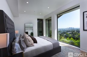 West Hollywood house for rent - A bedroom with a large bed and a view of the city.
