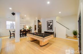 Houston townhouse for rent - A billiard table is in the middle of a spacious room with a dining table and chairs.