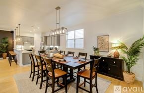 Houston townhouse for rent - A dining room with a table set for six and a kitchen area in the background.