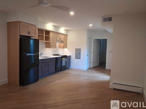 Altoona apartment for rent - A kitchen with wooden cabinets and a black fridge.