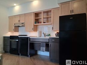 Altoona apartment for rent - A kitchen with wooden cabinets and black appliances.