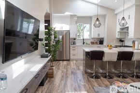 Los Angeles house for rent - A modern kitchen with a bar area and a television.