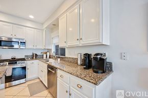Huntington Beach house for rent - A kitchen with white cabinets and granite countertops.