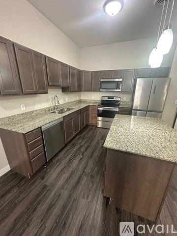 Mankato apartment for rent - A kitchen with dark wood cabinets and granite countertops.