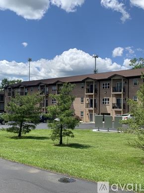 Cincinnati apartment for rent - Apartment complex with green grass and trees in front.