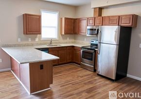 Cincinnati apartment for rent - A kitchen with wooden cabinets and a stainless steel refrigerator.
