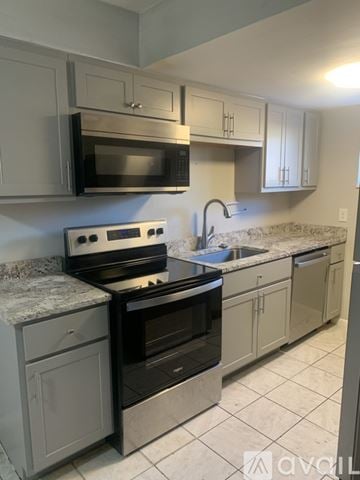 Cincinnati apartment for rent - A kitchen with a stove top oven and microwave above it.