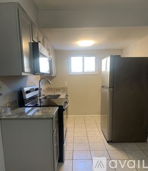 Cincinnati apartment for rent - A kitchen with a refrigerator, microwave, oven, and sink.