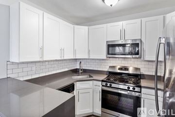 Chicago apartment for rent - A kitchen with white cabinets and a stainless steel refrigerator.
