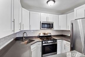 Chicago apartment for rent - A kitchen with white cabinets and a stainless steel refrigerator.