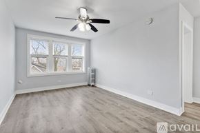 Chicago apartment for rent - A room with a ceiling fan and a window with a view of trees.