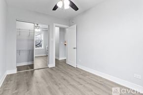 Chicago apartment for rent - A room with a ceiling fan and a door leading to another room.