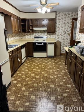 Carlisle apartment for rent - A house with a white garage is surrounded by a green lawn.