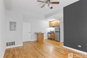 Chicago apartment for rent - A spacious living room with a ceiling fan and hardwood floors.