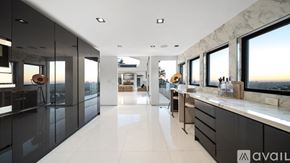 Los Angeles house for rent - A modern kitchen with marble countertops and a large window overlooking a sunset.