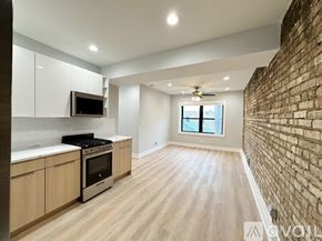 Chicago apartment for rent - A kitchen with wooden floors and a brick wall.