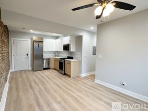Chicago apartment for rent - A kitchen with a refrigerator, microwave, oven, and sink is available for rent.