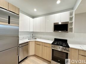 Chicago apartment for rent - A modern kitchen with a stainless steel refrigerator and a stove top oven.