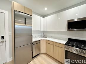 Chicago apartment for rent - A modern kitchen with a stainless steel refrigerator and wooden cabinets.