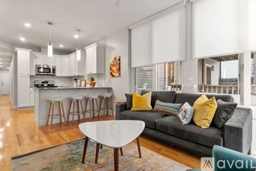 Boston apartment for rent - A modern living room with a grey couch and a white coffee table.
