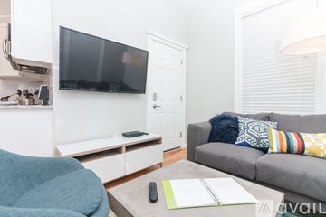 Boston apartment for rent - A living room with a grey couch and a television.