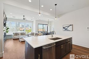 Dallas townhouse for rent - A modern kitchen with dark wood cabinets and a white countertop.