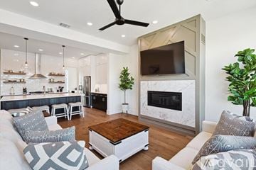 Dallas townhouse for rent - A modern living room with a fireplace and a television mounted on the wall.