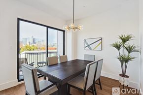 Dallas townhouse for rent - A dining room with a wooden table and chairs, a potted plant, and a framed picture on the wall.