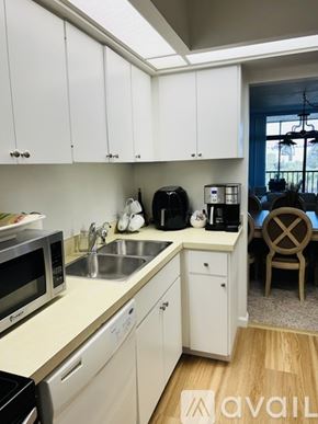 Longboat Key condo for rent - A kitchen with white cabinets and a wooden floor.