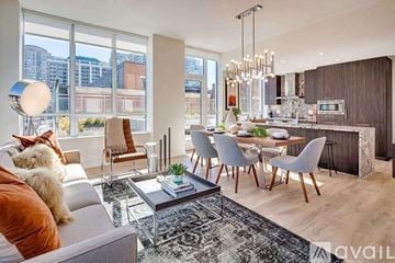 Chicago apartment for rent - A modern living room with a grey sofa, a coffee table, and a dining table with chairs.