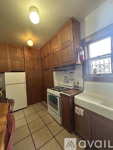 Gainesville apartment for rent - A kitchen with wooden cabinets and a white stove top oven.