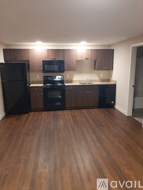 Lowell apartment for rent - A kitchen with black appliances and wooden floors.