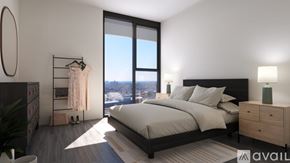 Chicago apartment for rent - A bedroom with a large bed, a dresser, and a window overlooking a cityscape.