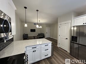 Lehi apartment for rent - A modern kitchen with white cabinets and a marble countertop.