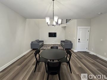 Lehi apartment for rent - A living room with a black table and chairs and a television.
