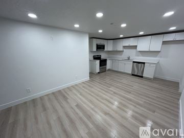 Lehi townhouse for rent - A spacious kitchen with wooden flooring and white cabinets.