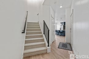 Lehi apartment for rent - A staircase with a beige carpeted runner and black handrails.
